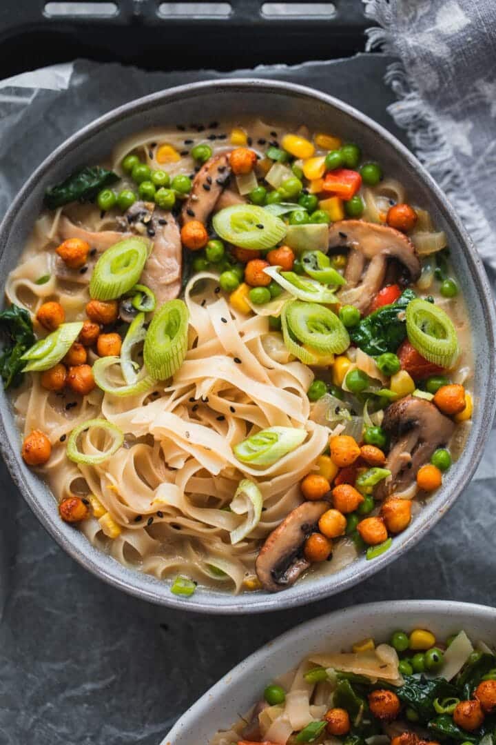 Bowl of soup with vegetables, noodles and spinach