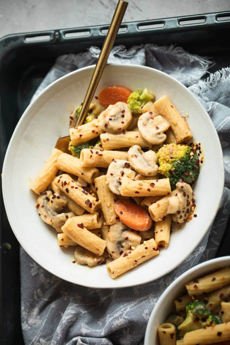 Bowl of vegan pasta with broccoli and carrots