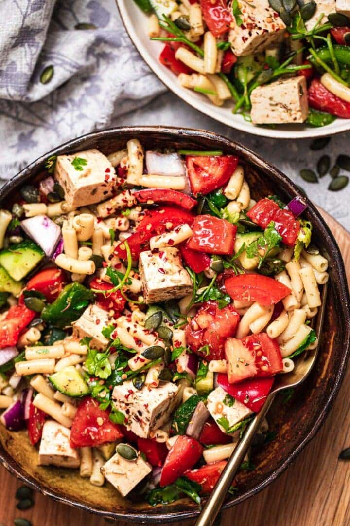 Bowl of vegan macaroni salad with tofu feta and vegetables