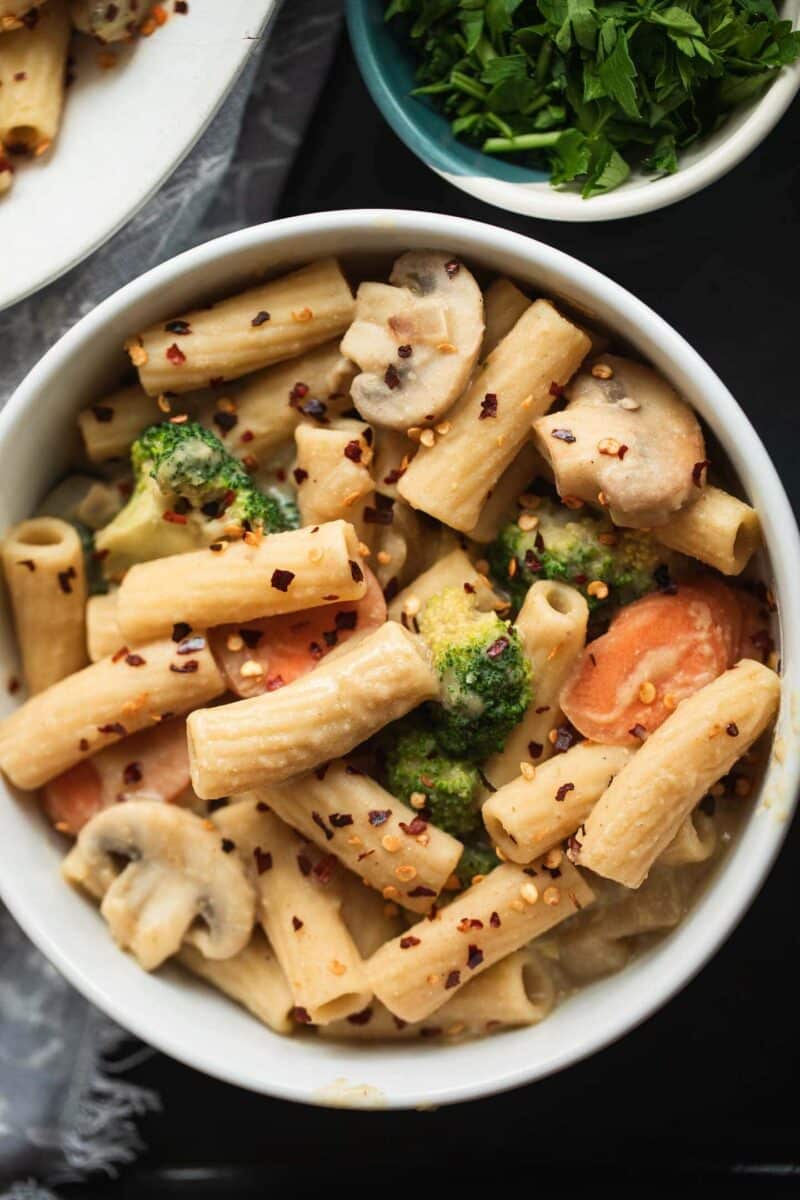 Bowl of vegan pasta with vegetables and a creamy sauce