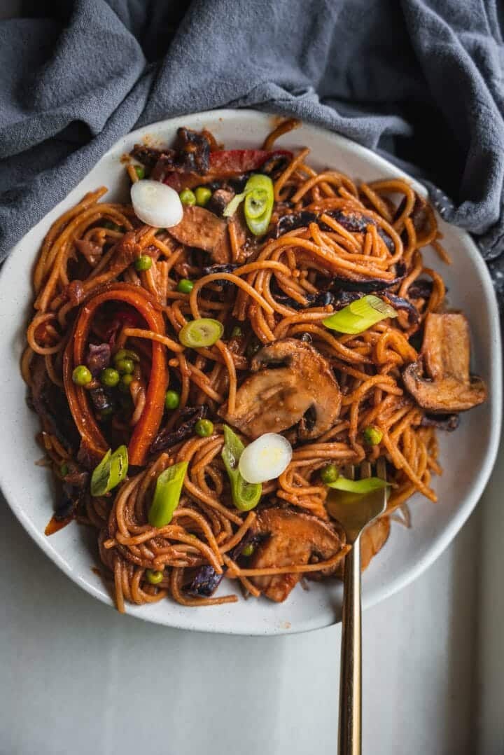 Bowl of vegan pasta with vegetables and spring onion