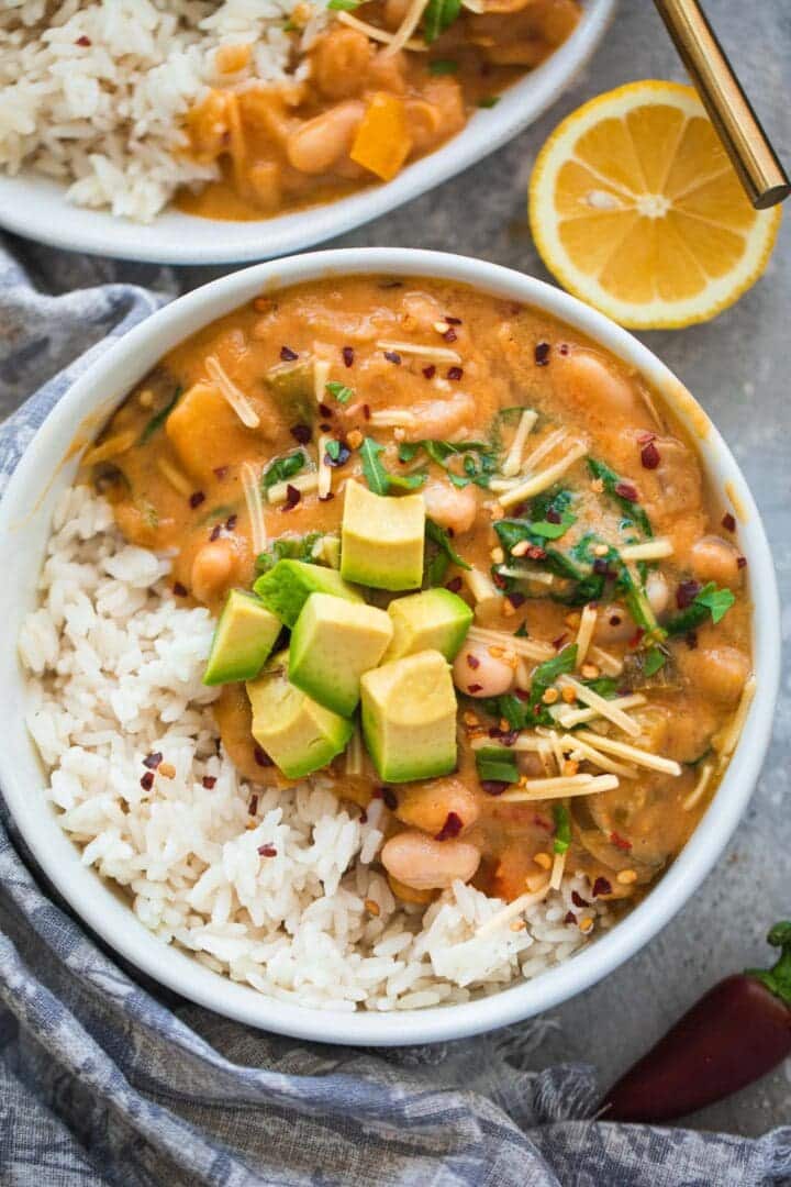 Bowl of white bean chili with avocado and rice