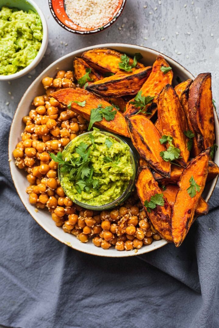 Bowl with homemade sweet potato wedges, chickpeas and guacamole