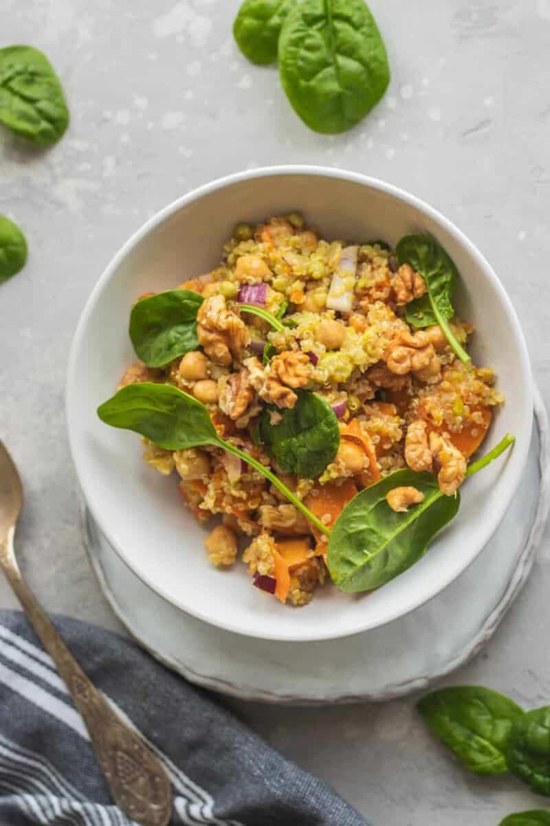 Bowl of vegan chickpea quinoa salad with pumpkin and spinach