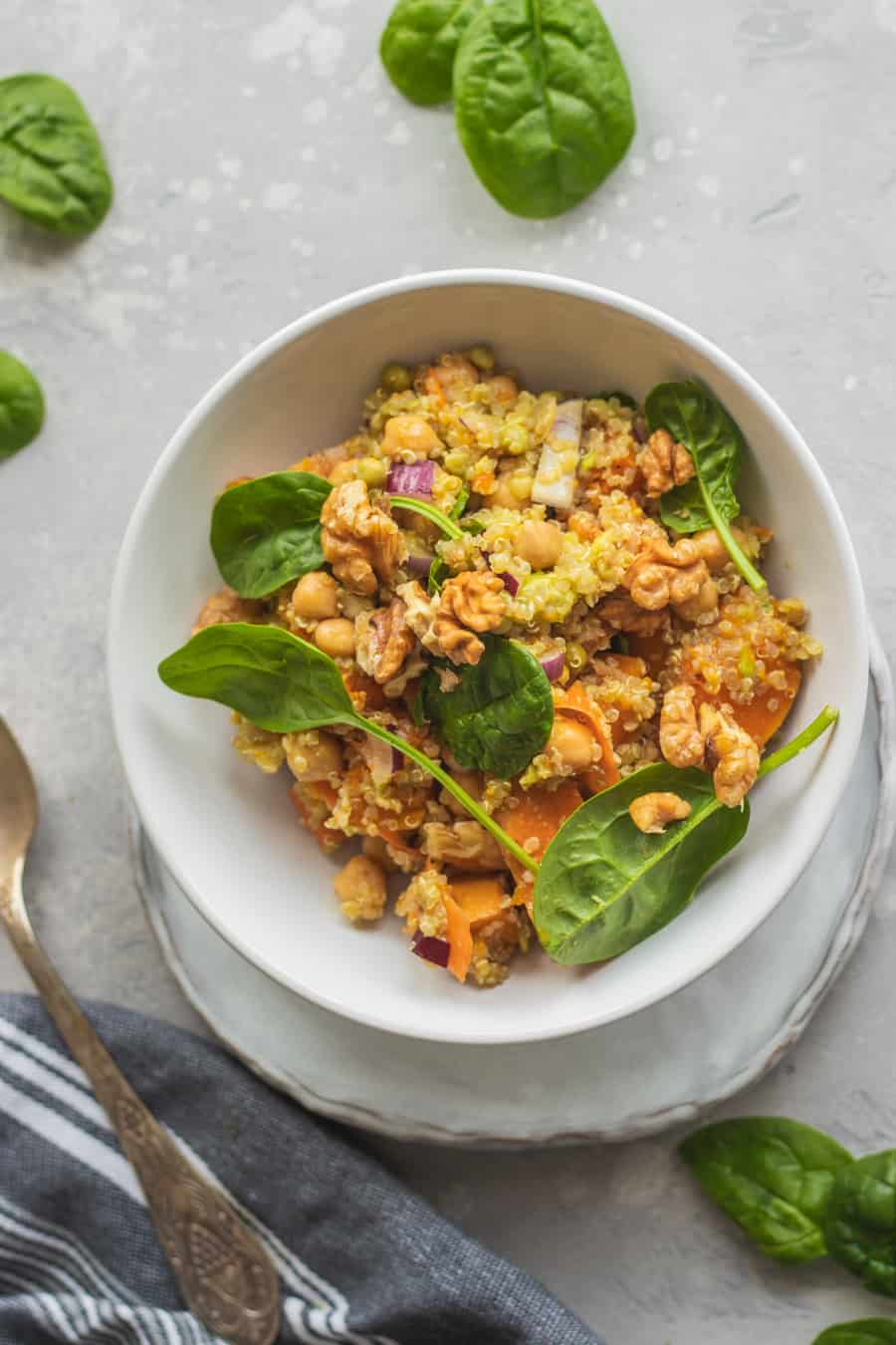 High protein pumpkin salad with quinoa, chickpeas and spinach in a small white bowl