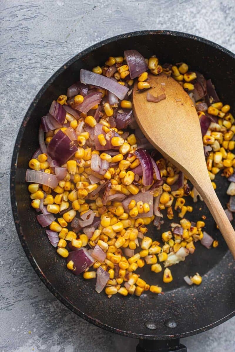 Sweetcorn and red onion in a saucepan