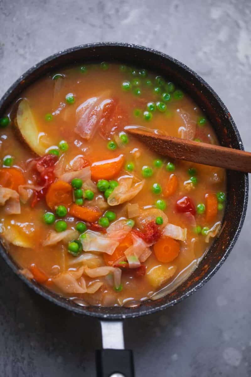 Chunky vegetable soup with potatoes and peas in a saucepan