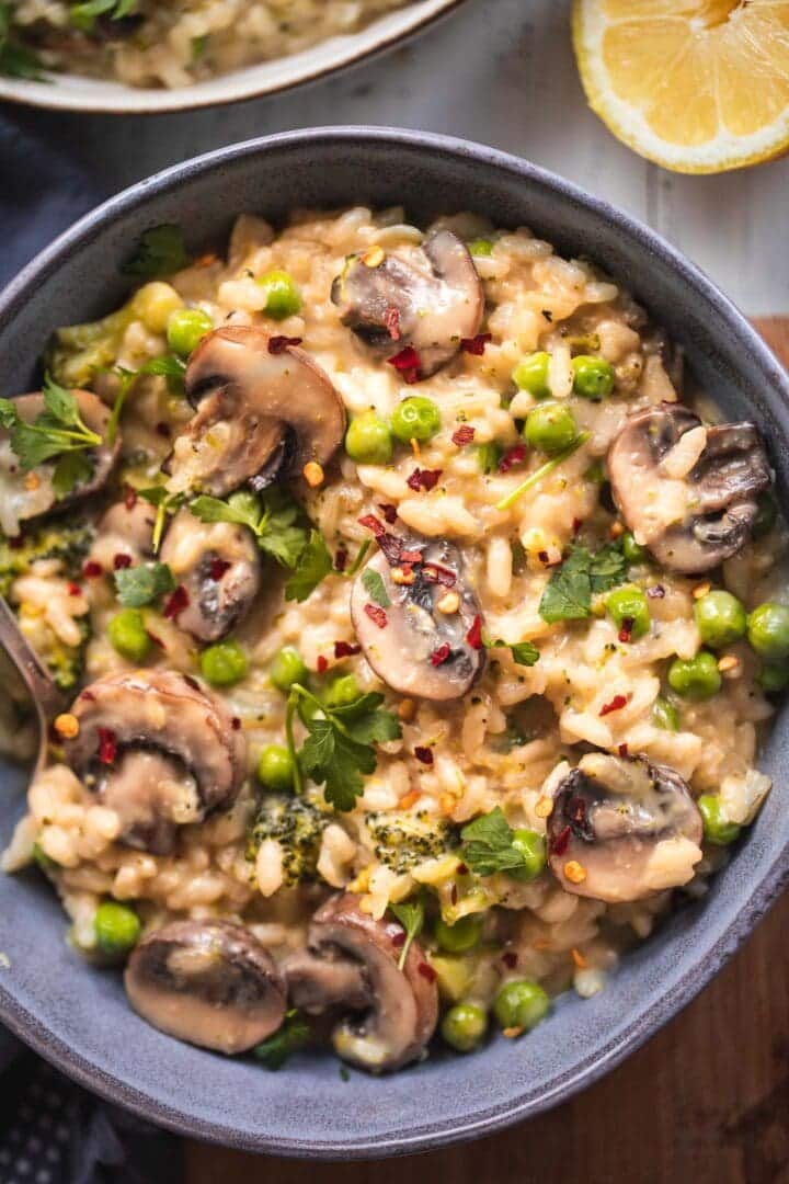 Closeup of a bowl of dairy-free mushroom risotto with green peas
