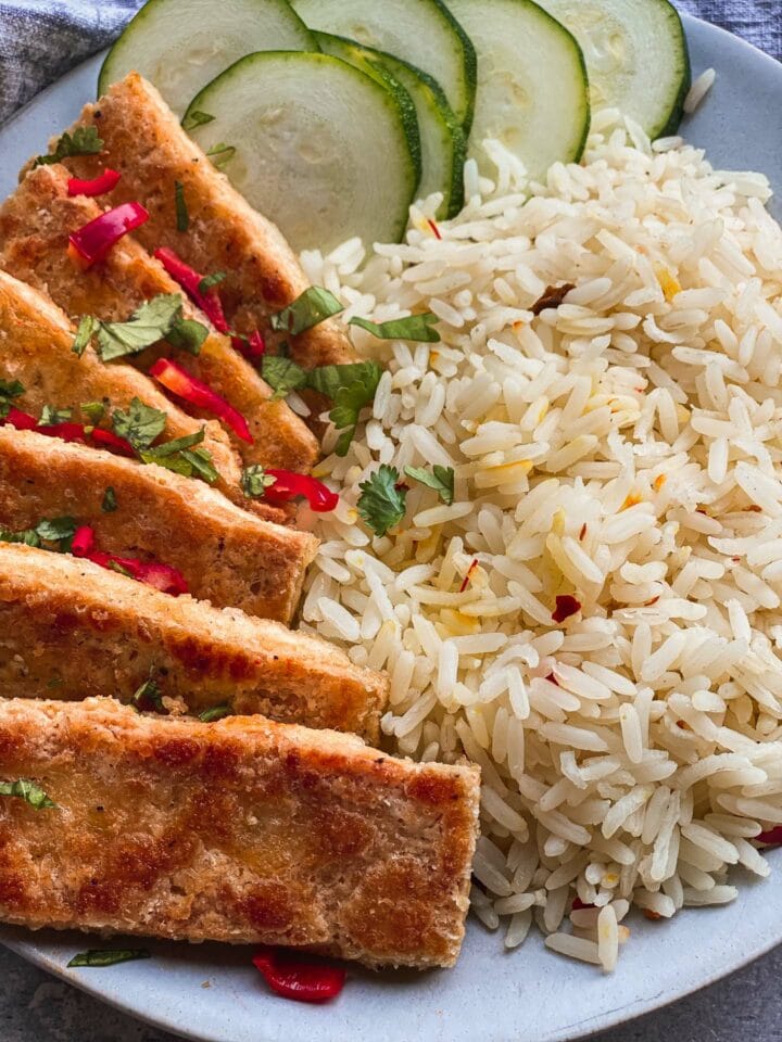 Closeup of salt and pepper tofu with rice and cucumber
