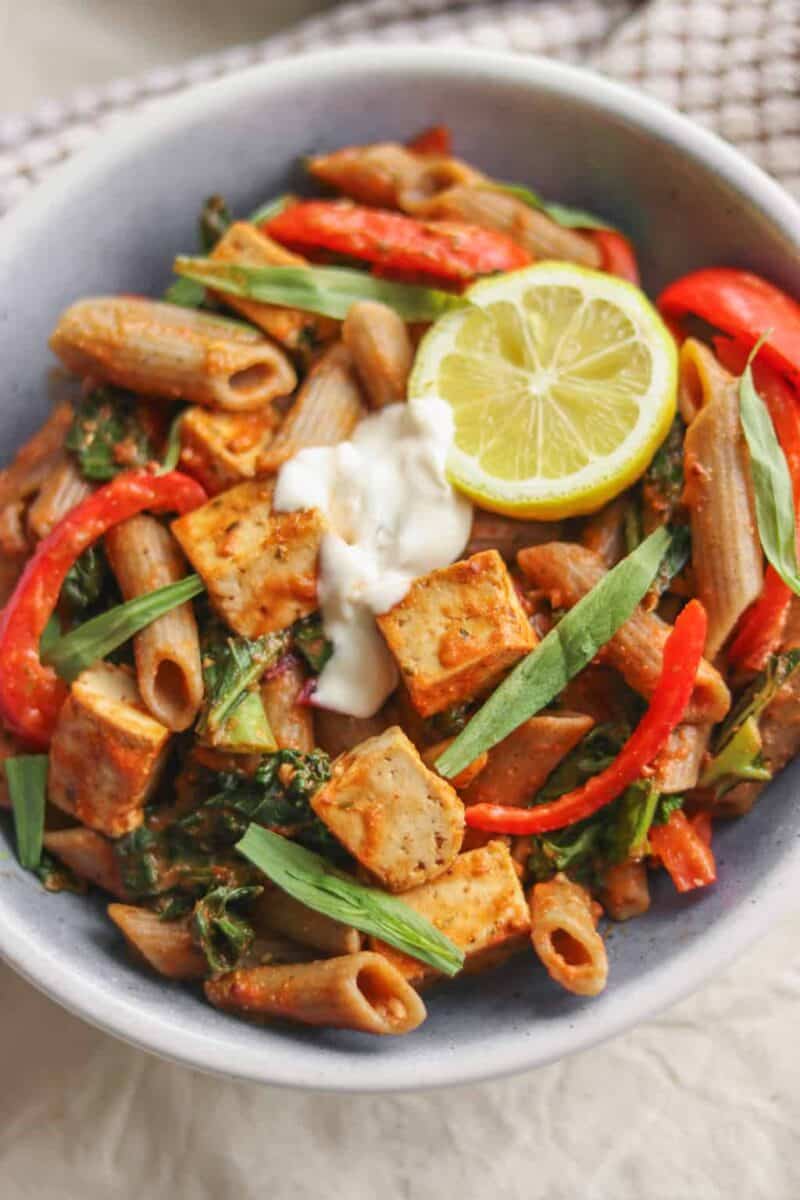 Bowl of creamy vegan tomato sauce pasta with tofu and red peppers