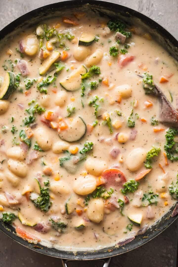 Dairy-free gnocchi soup with kale in a frying pan