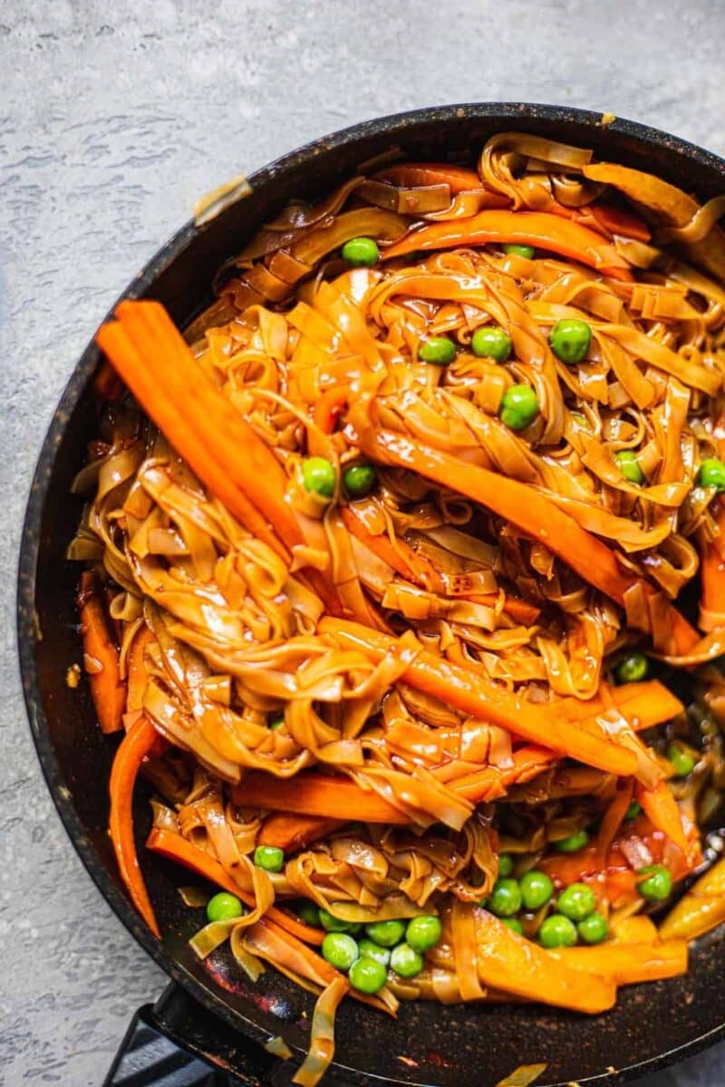 Close up of a frying pan with noodles and vegetables