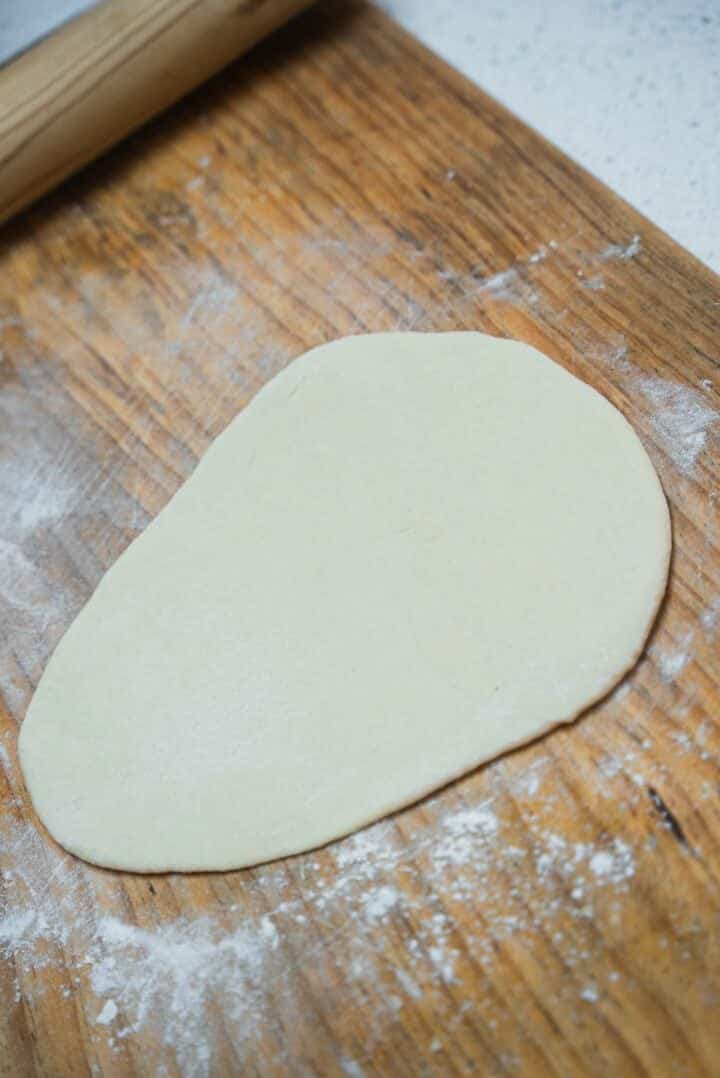 Eggless naan on a wooden board before cooking