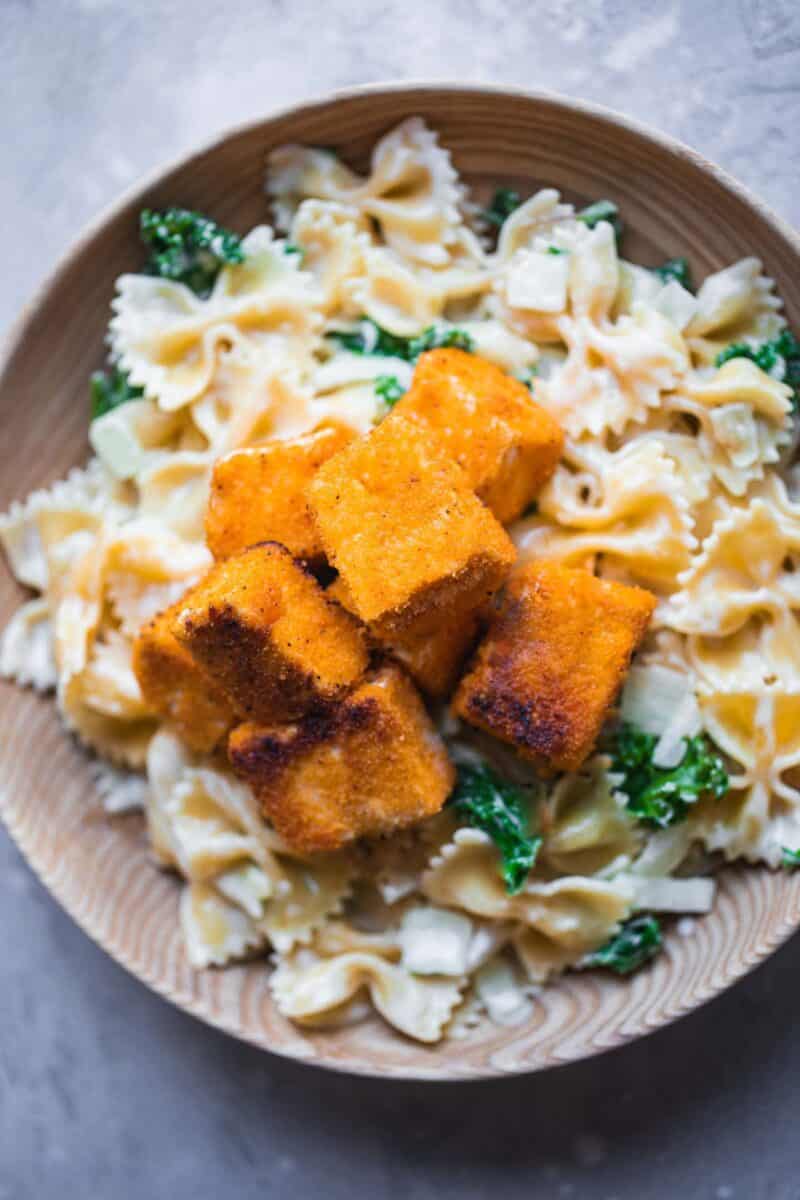 Fried tofu cubes over a bowl of pasta