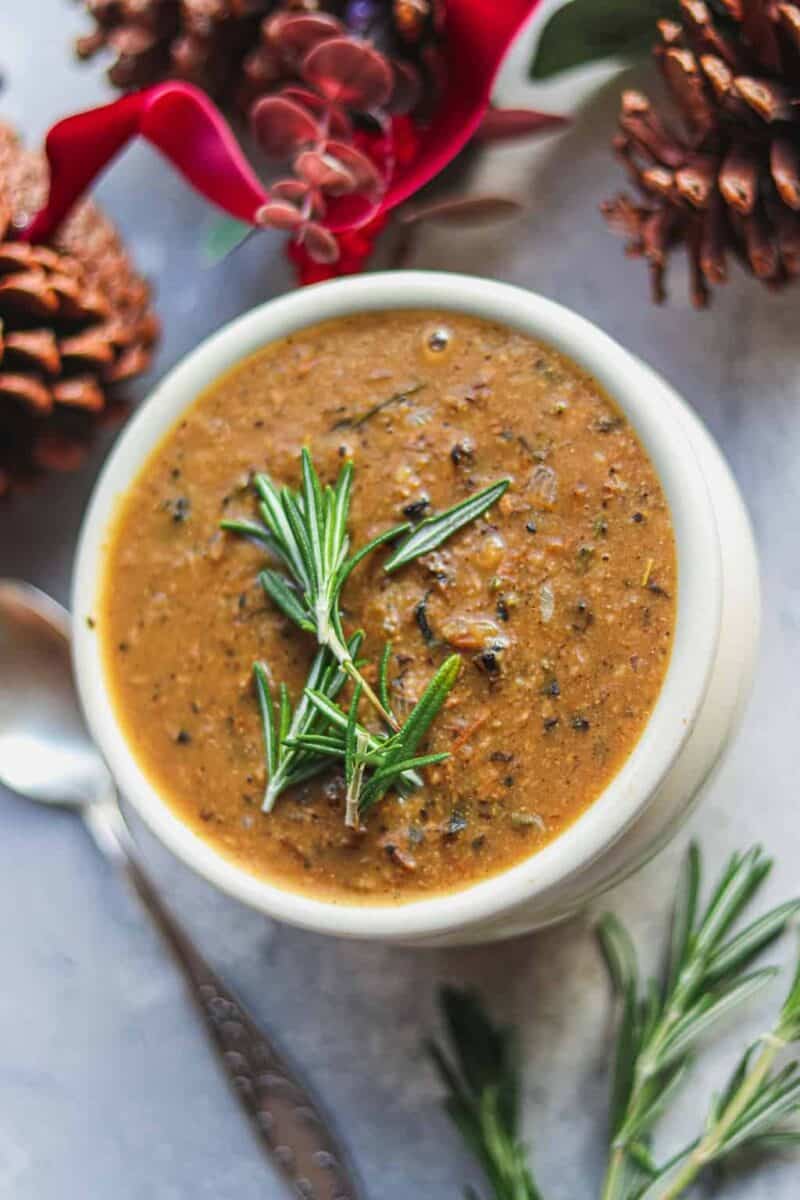 White pot with gravy and rosemary
