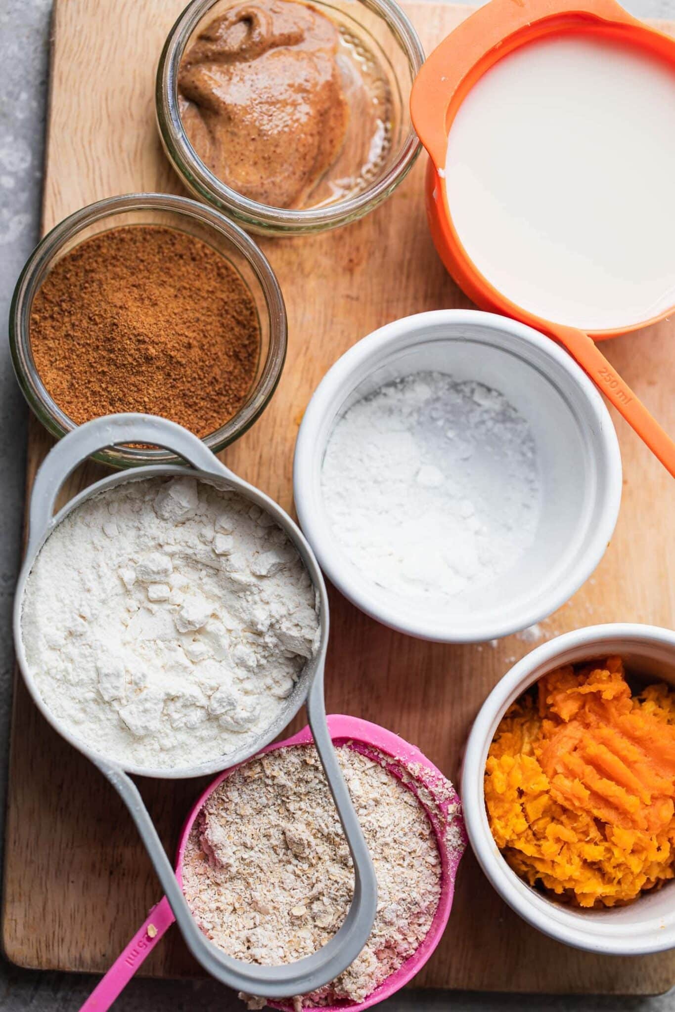 Ingredients for vegan pumpkin pancakes: pumpkin puree, almond butter, almond milk, oat flour, gluten-free flour, coconut sugar and baking powder