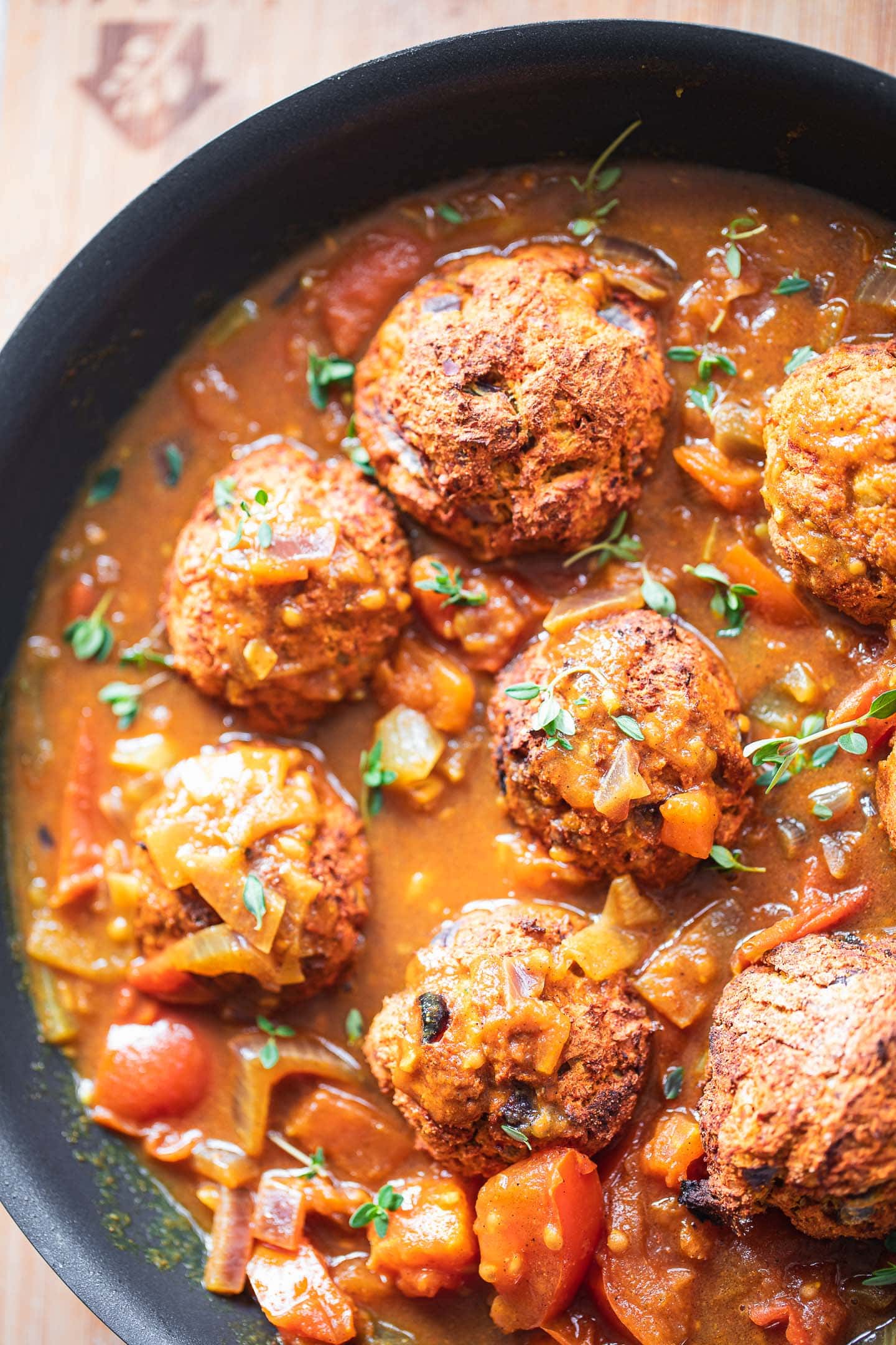 Lentil meatballs in a pan with a curry sauce