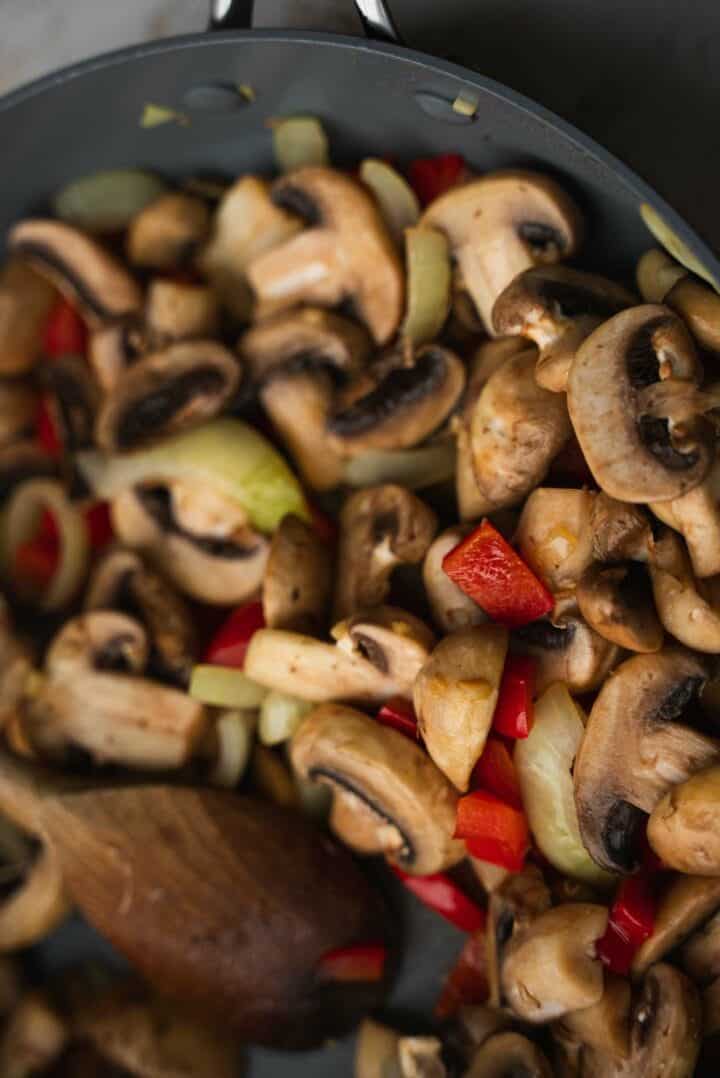 Mushrooms and peppers in a frying pan