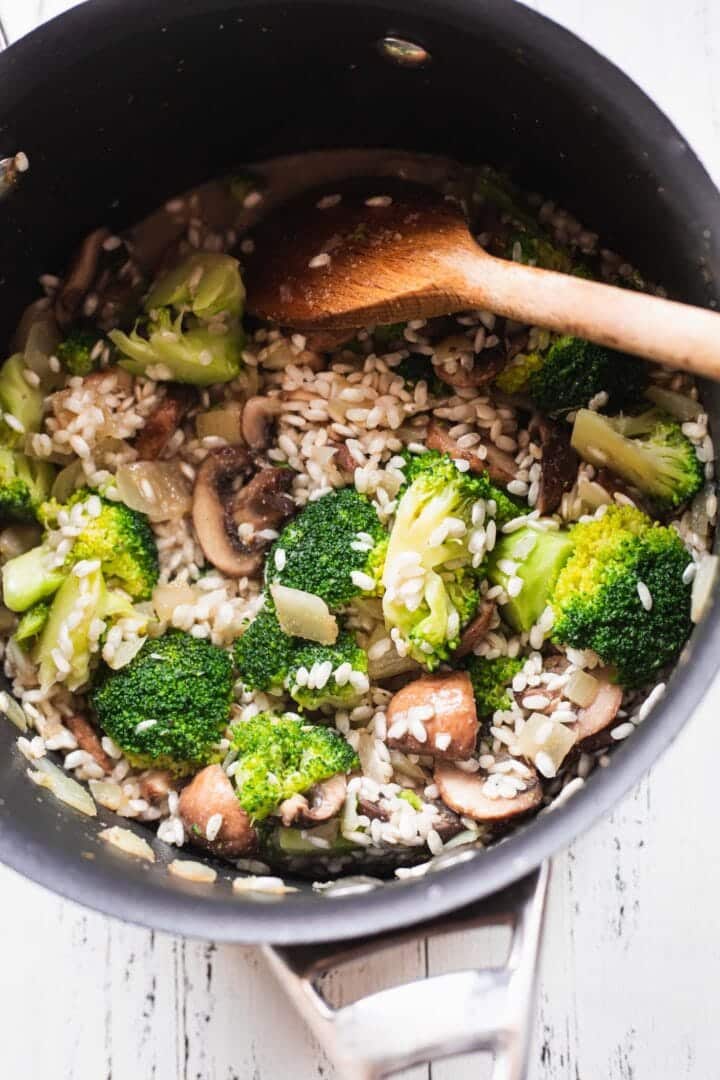 Mushrooms, broccoli and Arborio rice in a saucepan
