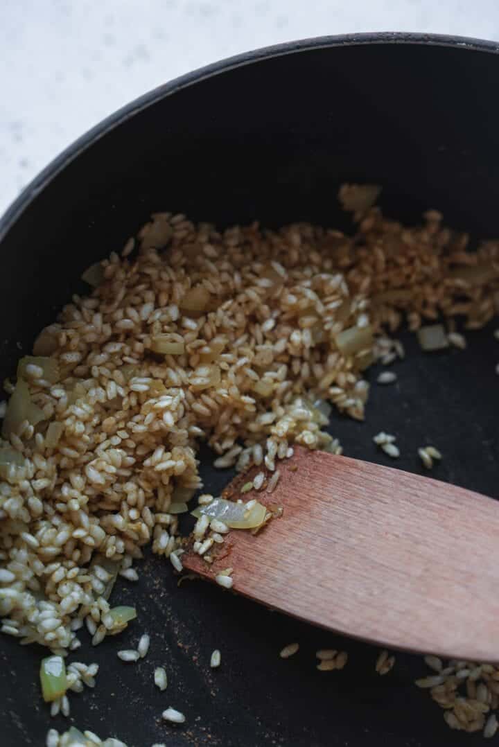 Onions and arborio rice in a frying pan