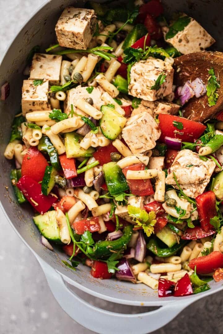 Pasta salad with tofu feta in a large mixing bowl