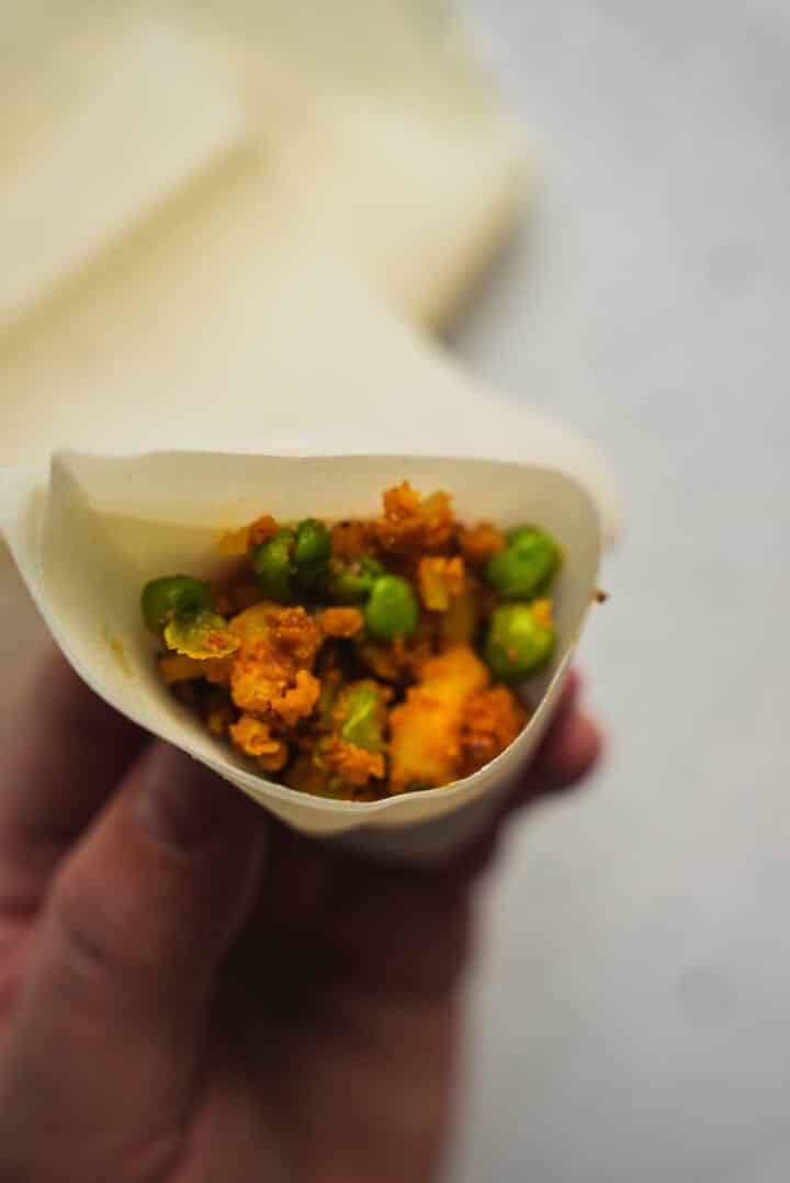 Potato filling being added to filo pastry