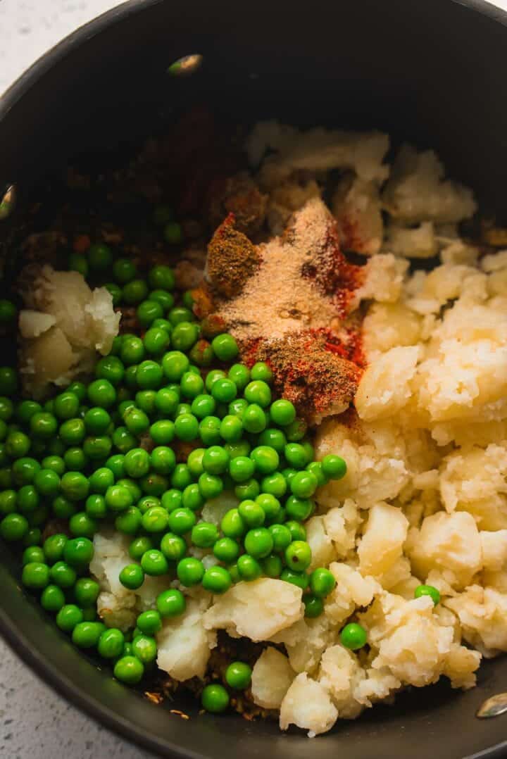 Potatoes, peas and spices in a saucepan