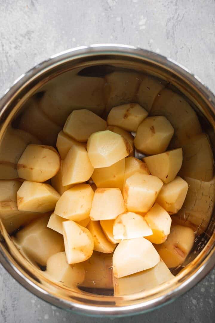 Potatoes soaking in a bowl of water