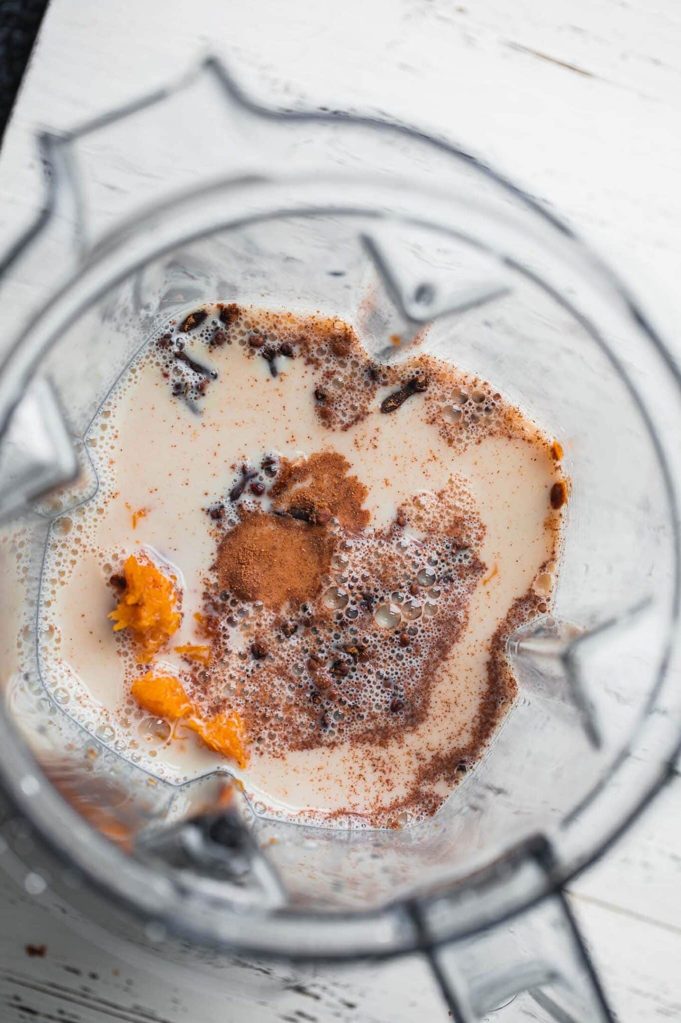 Pumpkin puree, banana, spices and plant-based milk in a blender