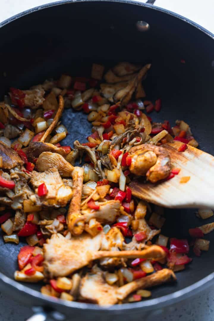 Red pepper, onion and oyster mushrooms in a saucepan