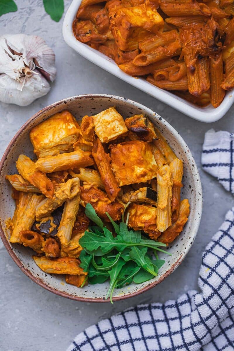 Pasta bake in a bowl with aubergine, tofu and leafy greens