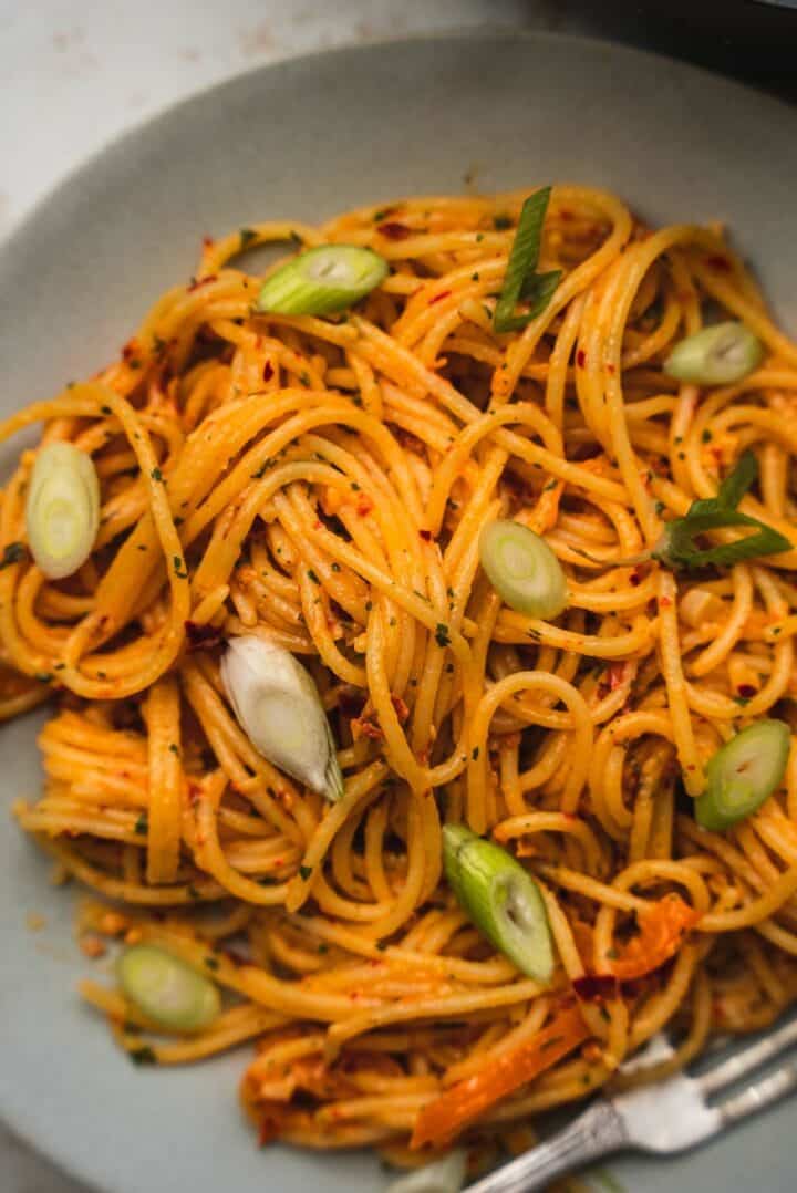 Spaghetti on a plate with peppers and scallions