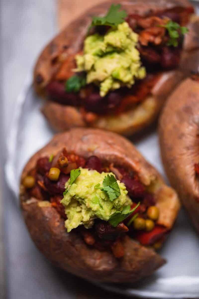 Baked potato with a bean filling and mashed avocado on top
