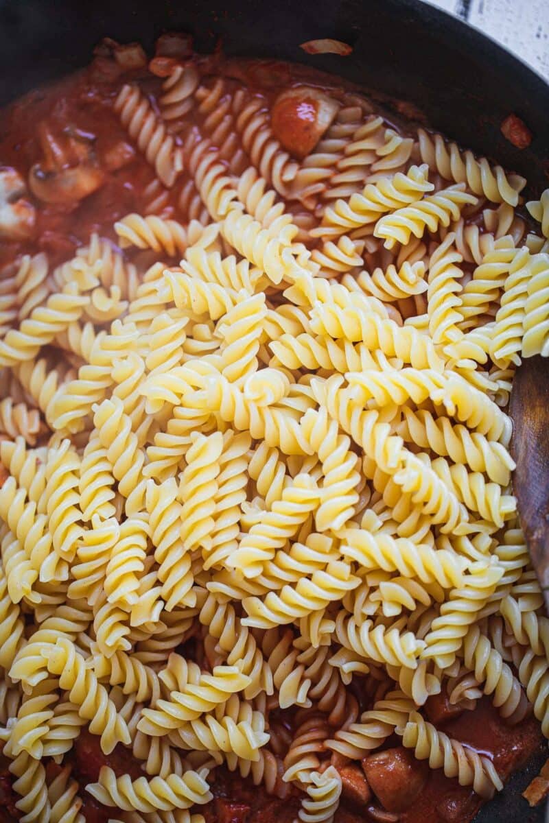 Pasta and a spicy pasta sauce in a frying pan