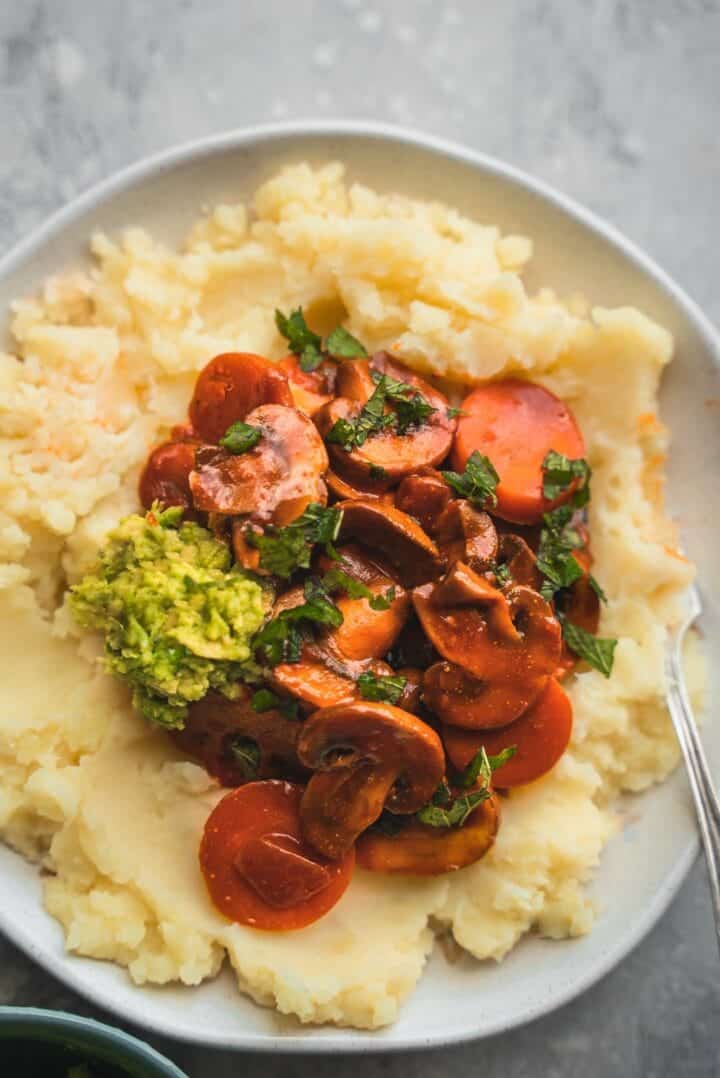 Stew with mushrooms and vegetables over mashed potatoes