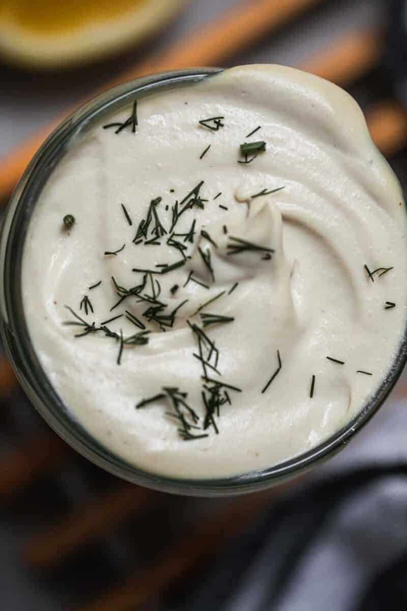 Closeup of a jar of vegan sour cream with dill