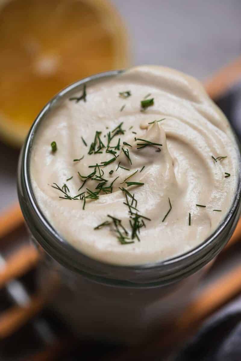 Closeup of vegan sauce in a jar with dill on top