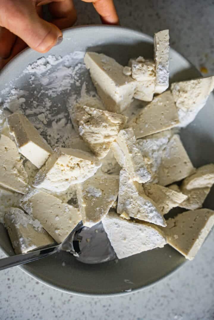 Tofu and cornstarch in a mixing bowl