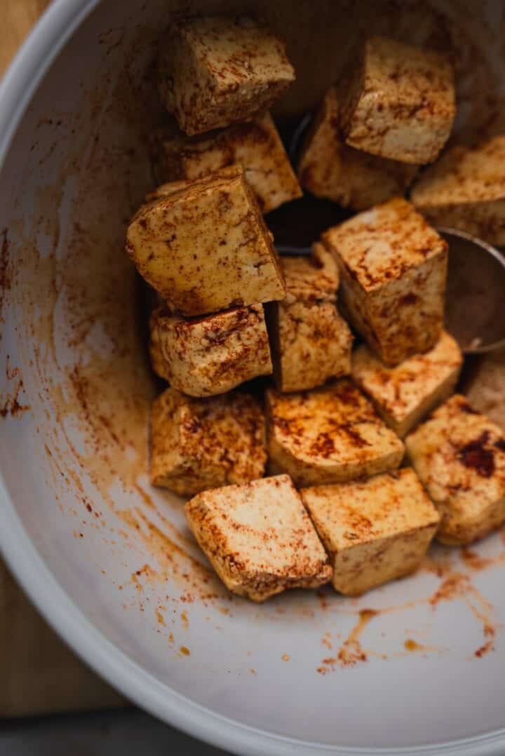 Tofu and spices in a mixing bowl
