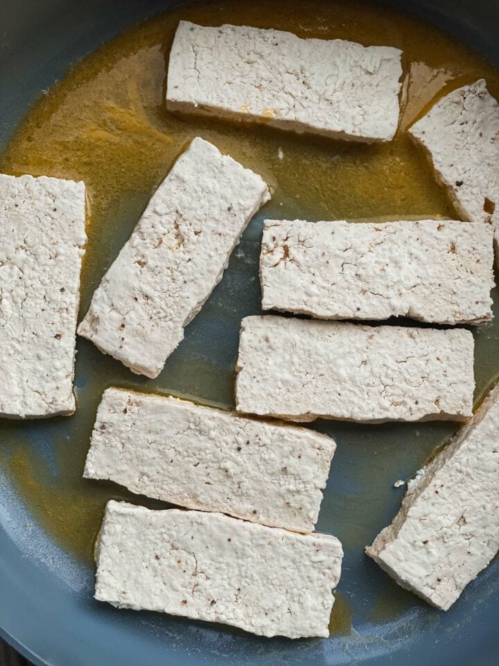 Tofu being cooked in a frying pan