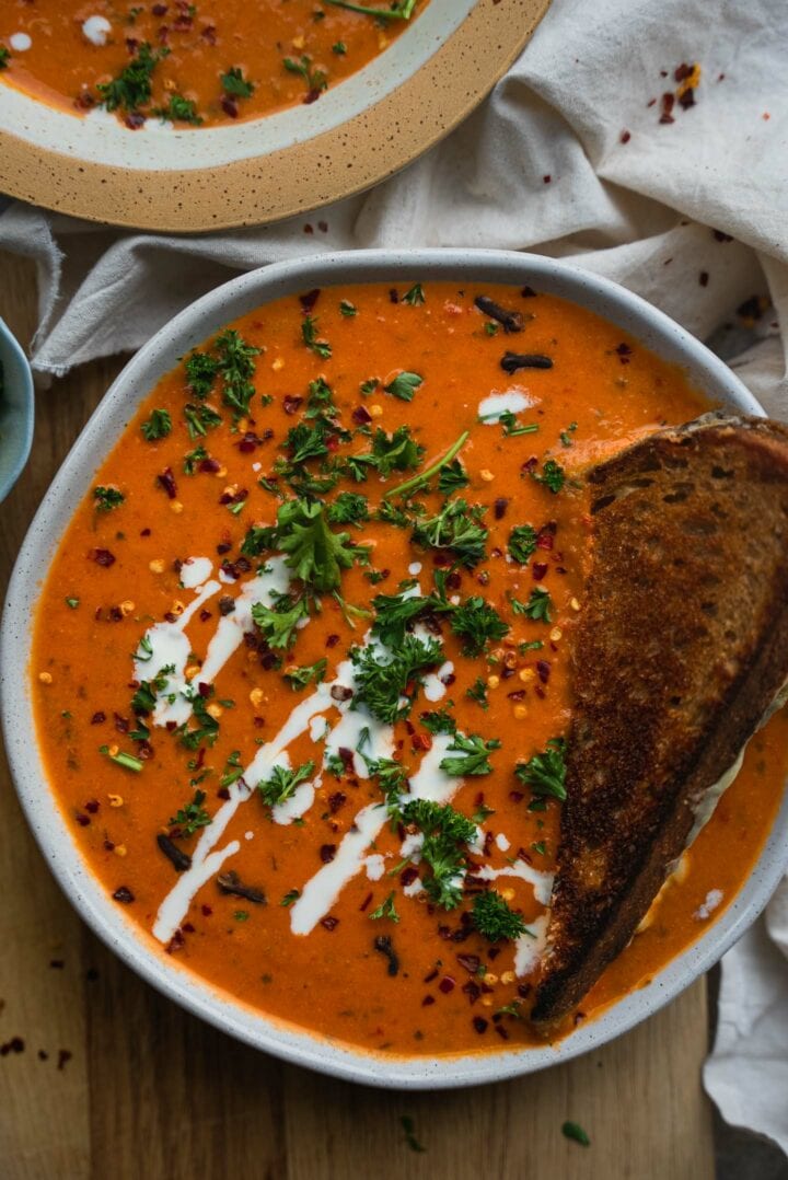 Tomato soup in a bowl with a grilled cheese sandwich