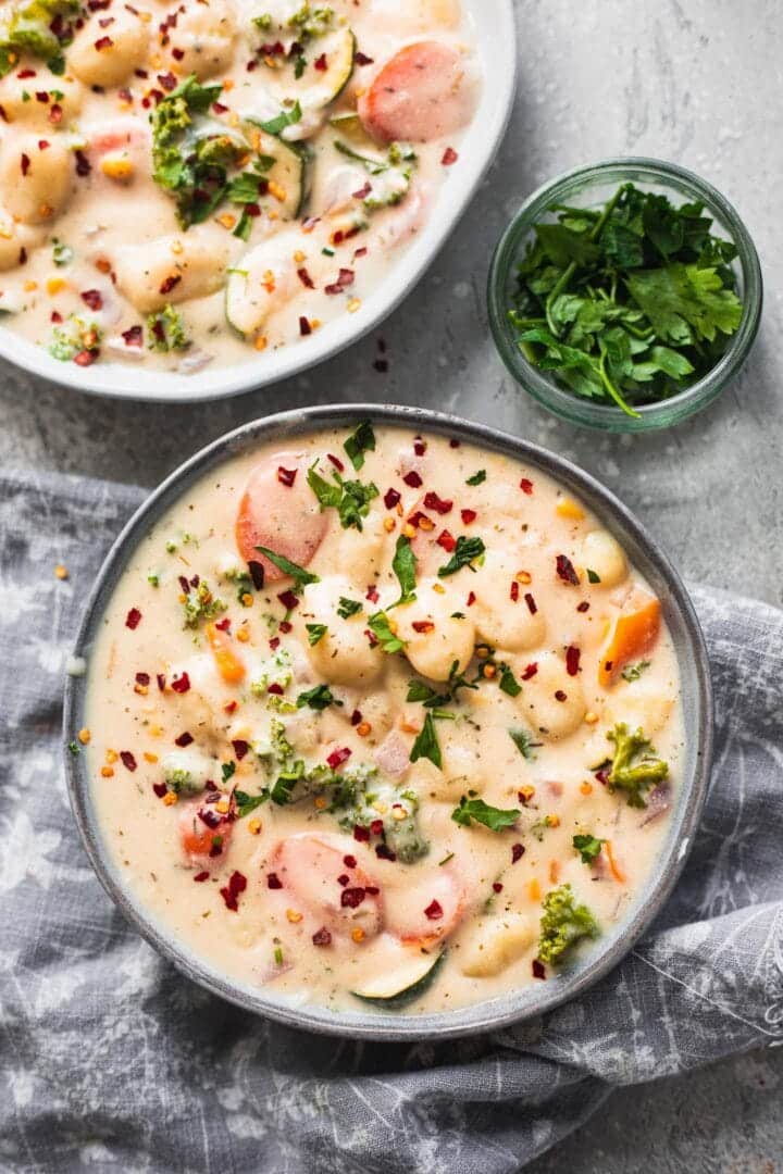 Two bowls of vegan gnocchi soup with kale