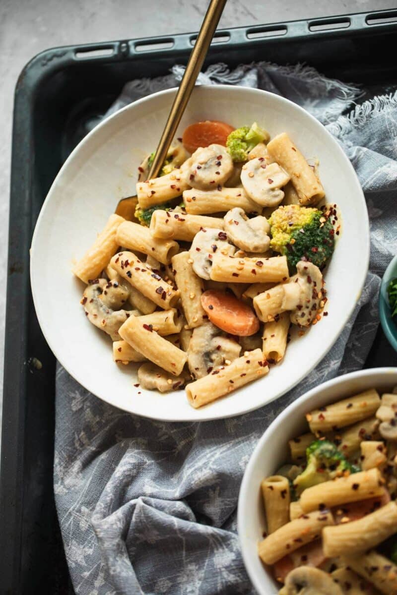 Two bowls of vegan pasta with vegetables