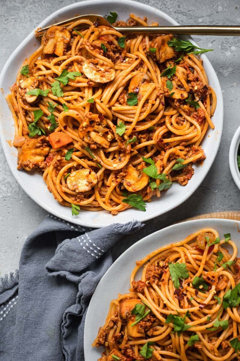 Two bowls of vegetarian spaghetti with a tomato pasta sauce