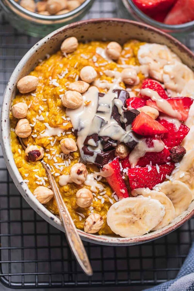 Bowl of vegan porridge with berries, banana and nuts as toppings