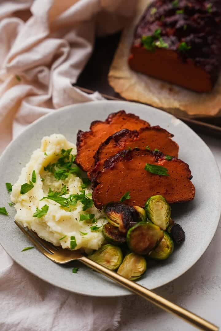 Vegan ham with mashed potatoes and Brussels sprouts