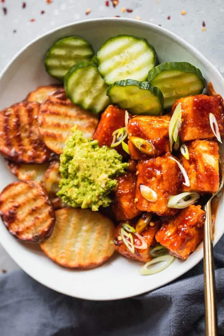 Vegan 'honey' BBQ tofu with potatoes and cucumber in a bowl