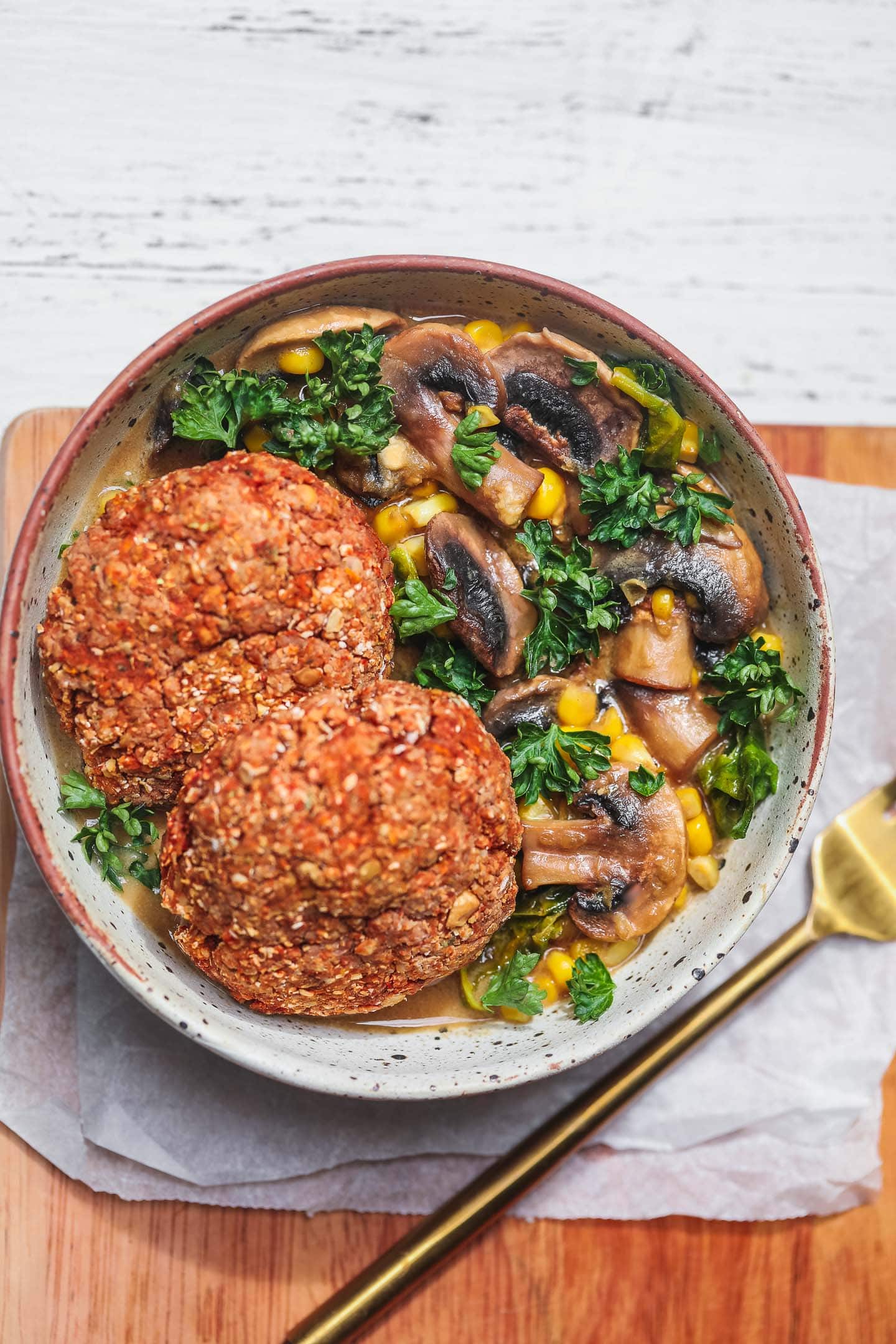 Vegan lentil burgers over a bowl of mushroom stew