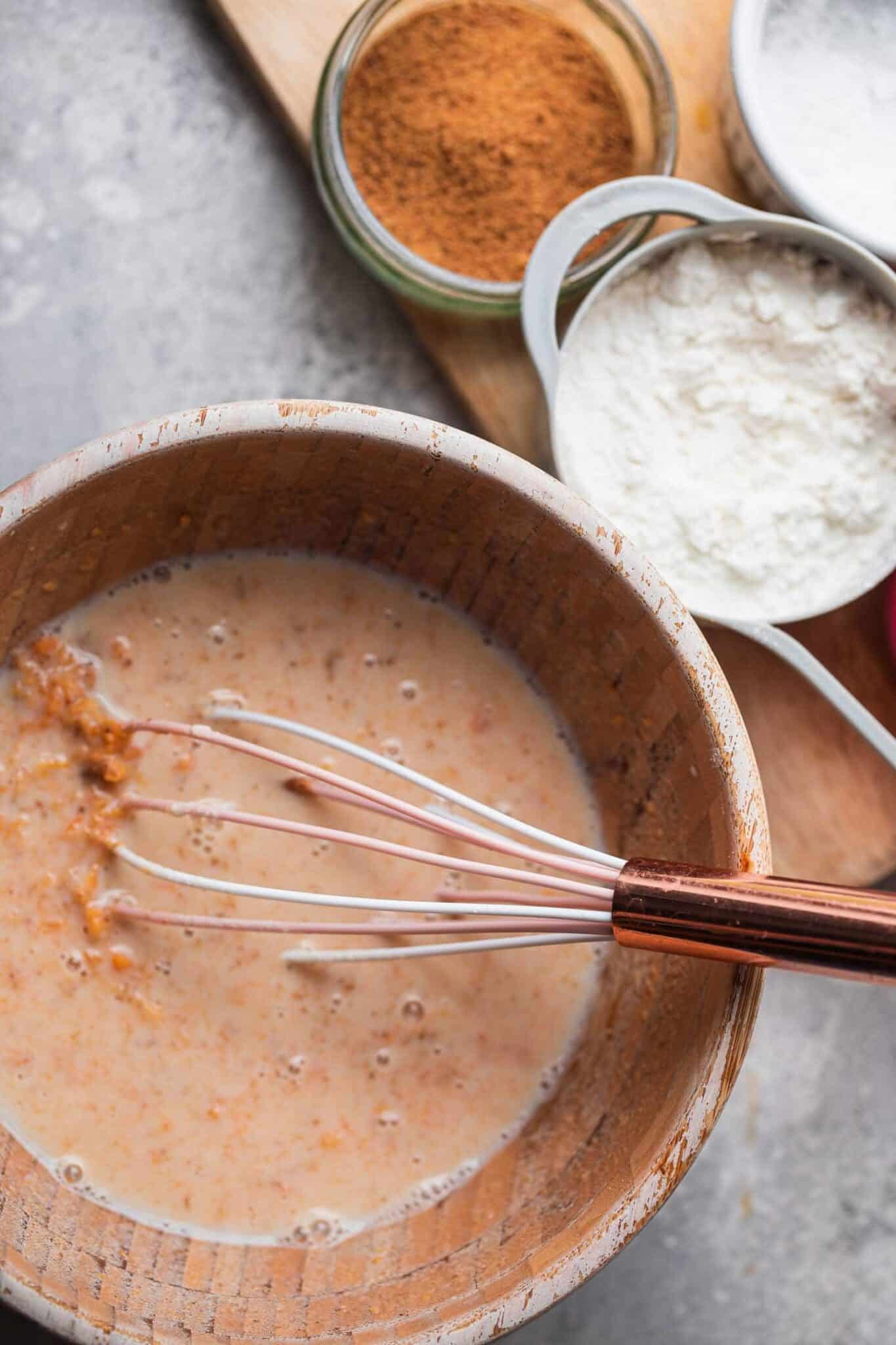 Pumpkin puree, almond butter and almond milk being whisked together in a mixing bowl