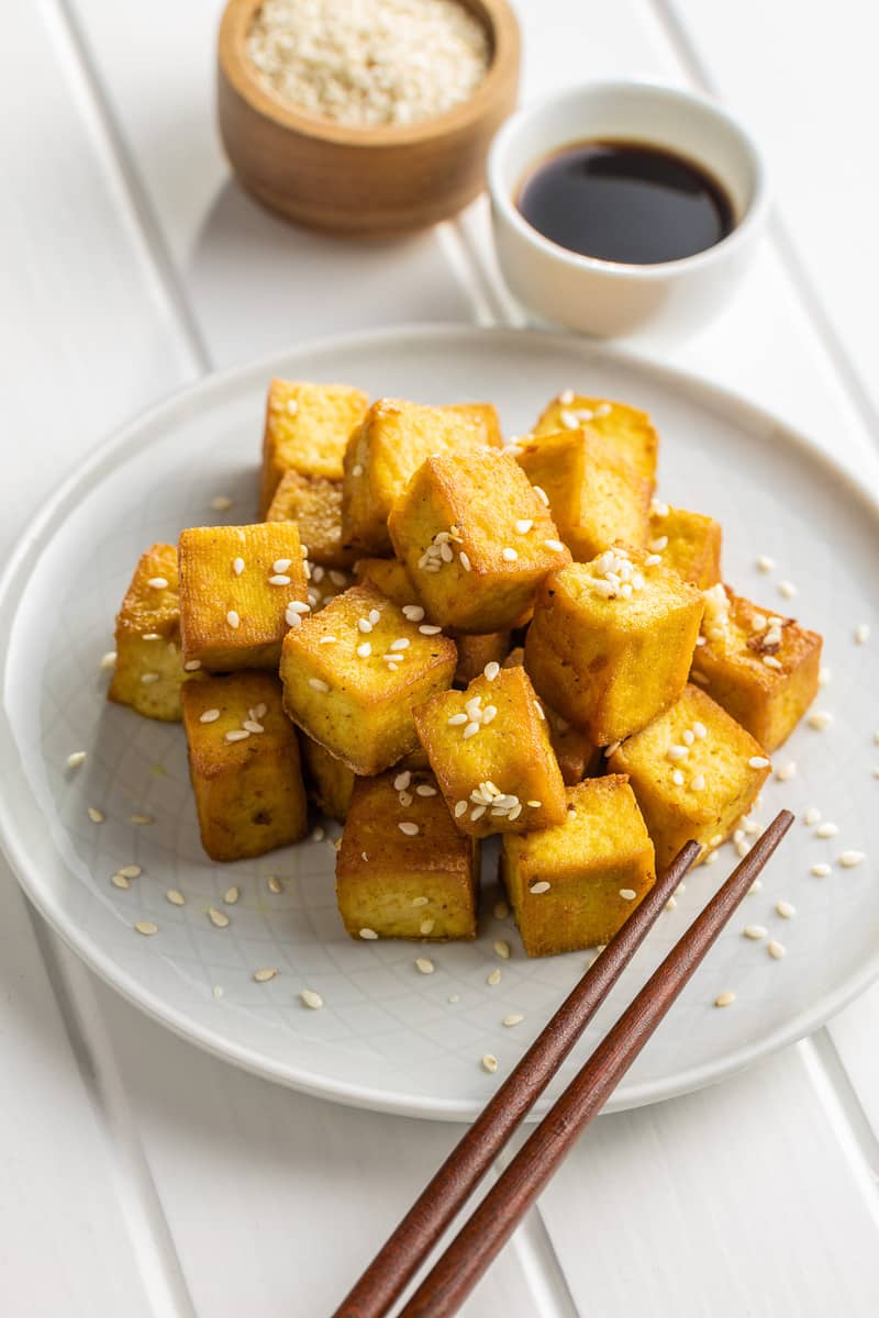easy marinated tofu on a white plate with wooden chopsticks
